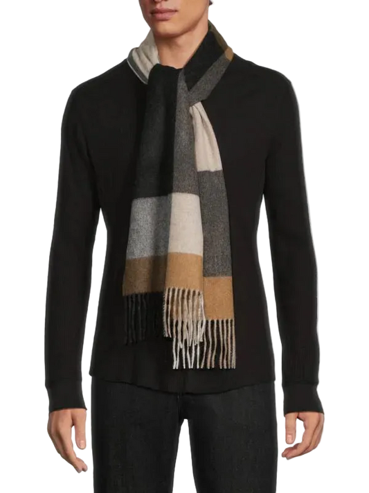 Person wearing a black sweater and a checkered scarf with fringes on a white background