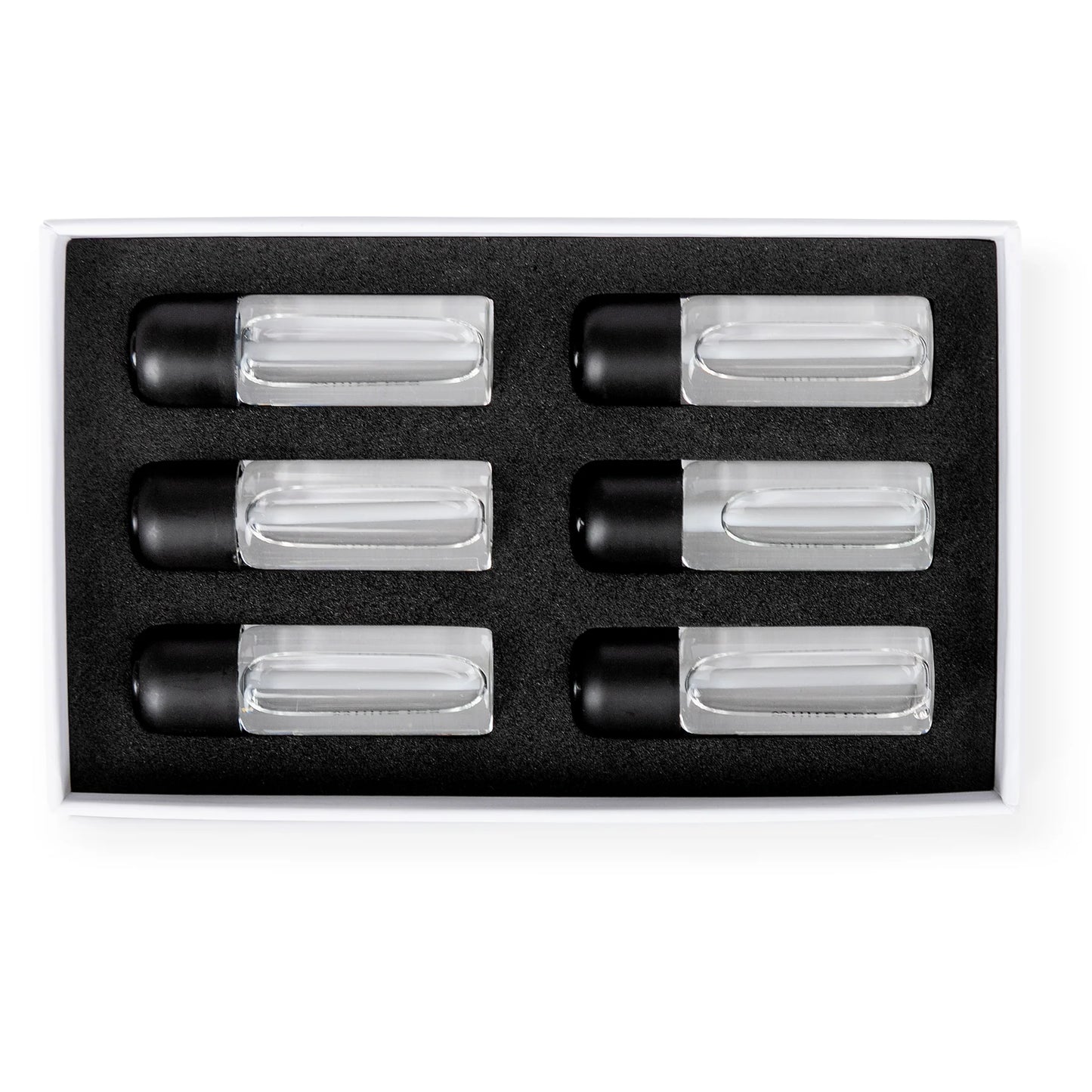 Set of six clear cylindrical containers with black lids in a black box on a white background